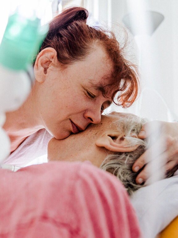 Angehörige nimmt Patientin in Arm